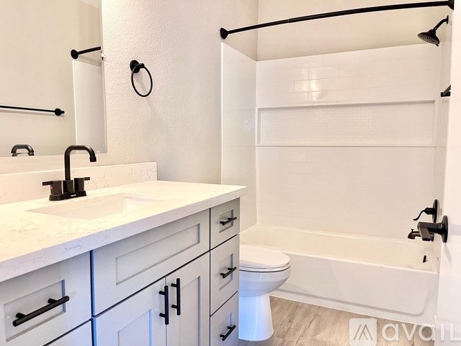 A white bathroom with a sink, toilet, and bathtub.