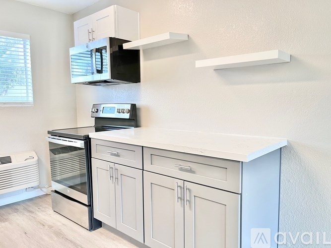 A kitchen with a stove, oven, and microwave.