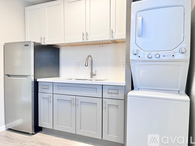A kitchen with white cabinets and a white dishwasher.