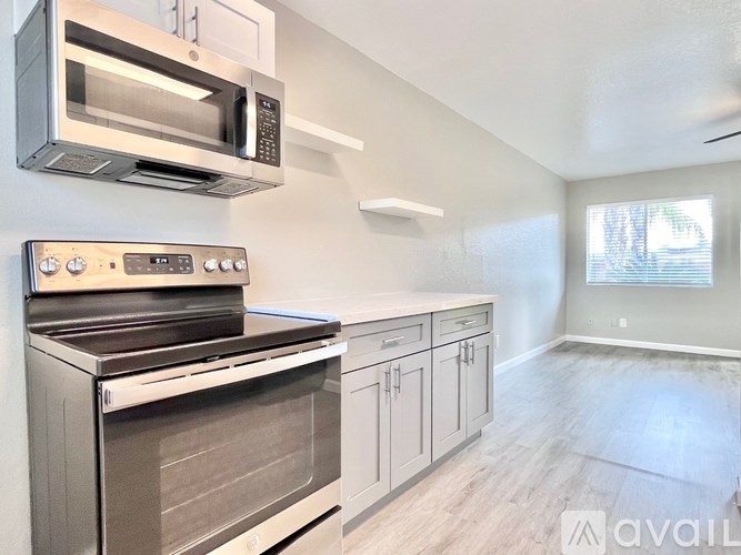A modern kitchen with stainless steel appliances and wooden cabinets.