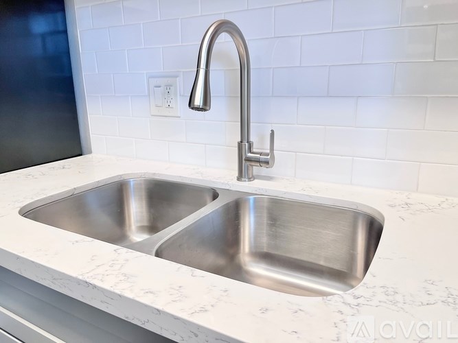 A modern kitchen sink with a chrome faucet.