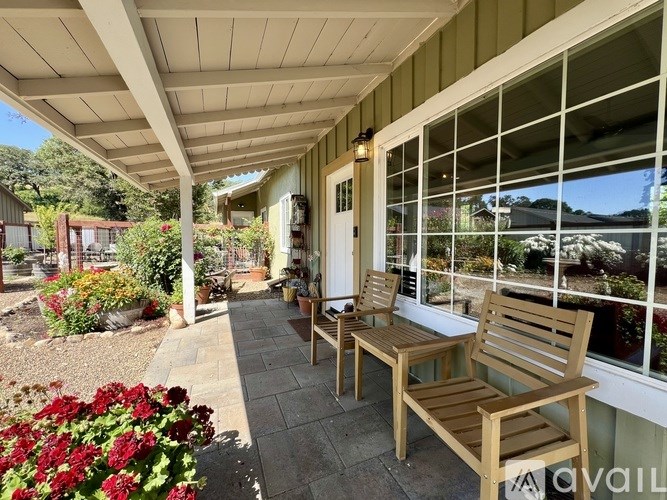 A patio with wooden benches and a view of the mountains.