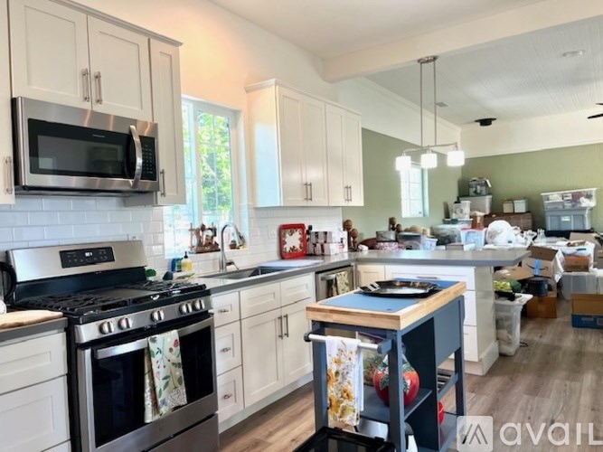 A kitchen with a stove, microwave, and oven.