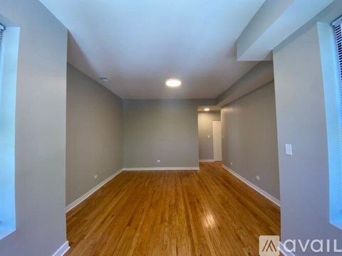 A room with wooden flooring and white walls.