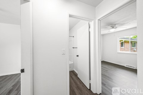A room with white walls and a window with a view of a building outside.