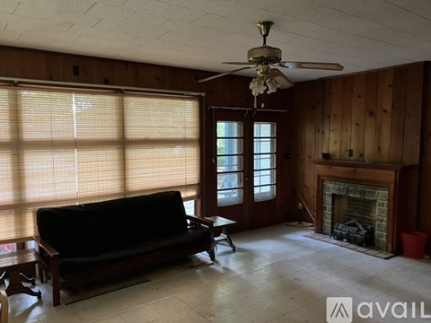 A living room with a black couch and a fireplace.