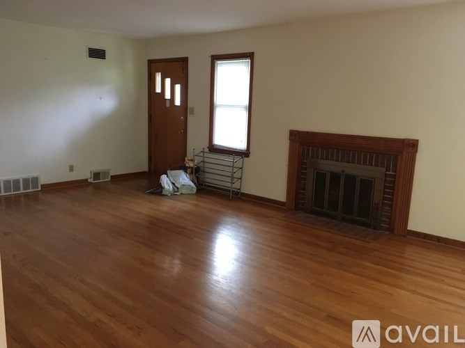 A room with a wooden floor and a fireplace.