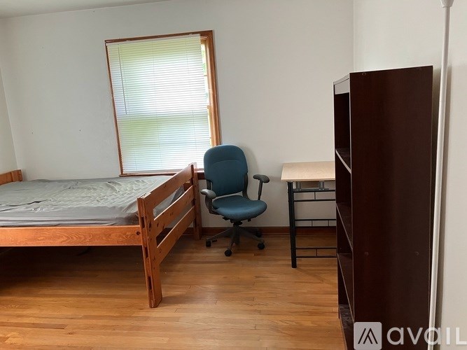 A bedroom with a bed, desk, and chair.