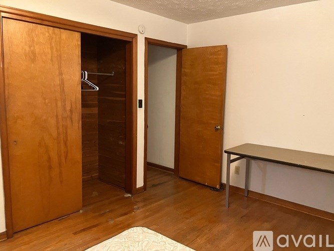 A room with a wooden wardrobe and a bench.