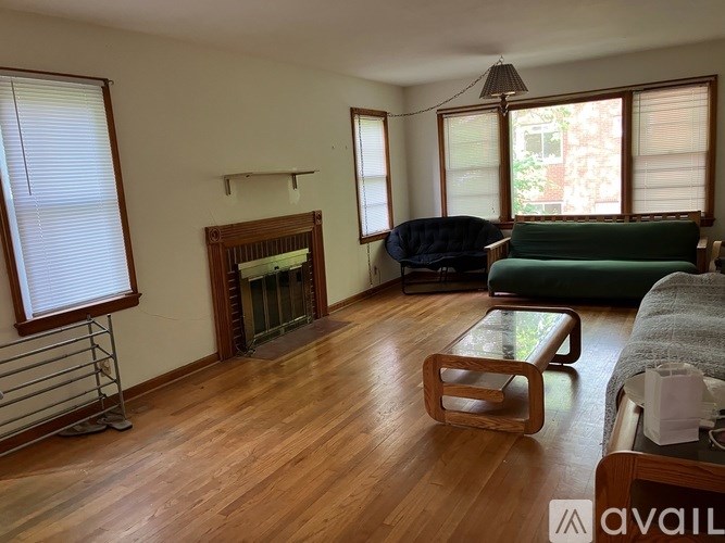 A living room with a fireplace and a green couch.
