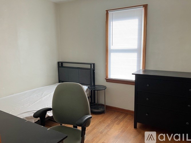 A room with a chair, a table, and a dresser.