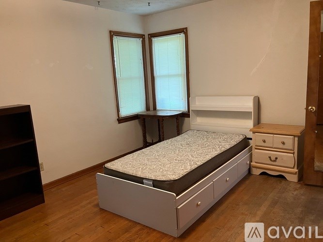 A bedroom with a bed, dresser, and window.