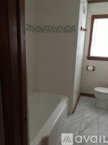 A bathroom with a tub, toilet and sink.