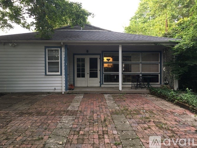 A house with a grey siding and a brick patio.