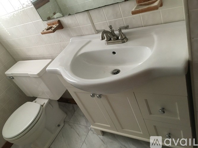 A white toilet and sink in a bathroom.