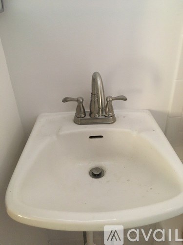 A white sink with a silver faucet in a bathroom.