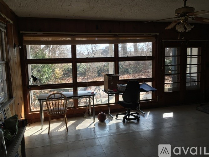 A room with a table and chairs in front of a large window.