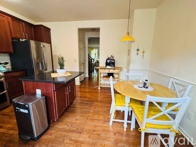 A kitchen with wooden floors and a table set for two.