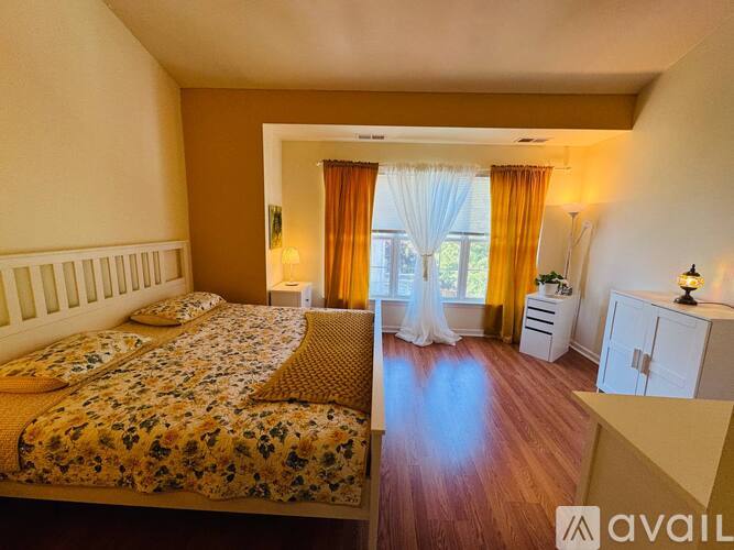 A bedroom with a large bed and a dresser.