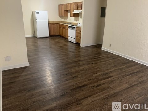 A kitchen area with a white refrigerator and wooden cabinets.