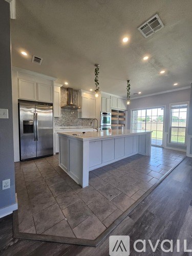 A kitchen with a white island and stainless steel appliances.