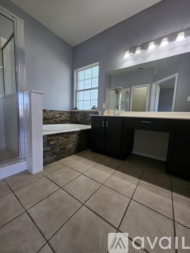 A bathroom with a large mirror and a window.