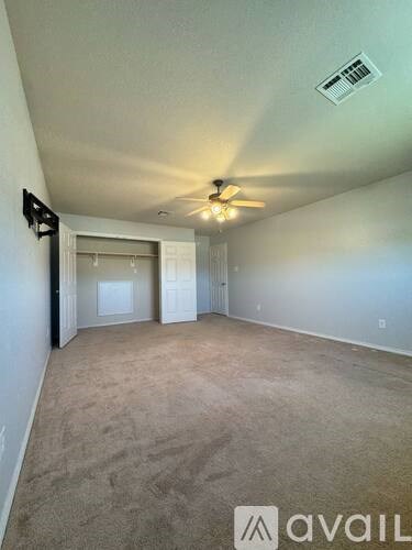 A room with a ceiling fan and carpeted floor.