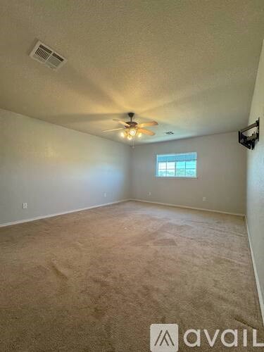 A room with a ceiling fan and a window.