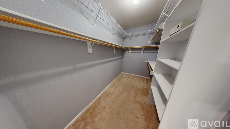 A room with a carpeted floor and a ceiling fan.