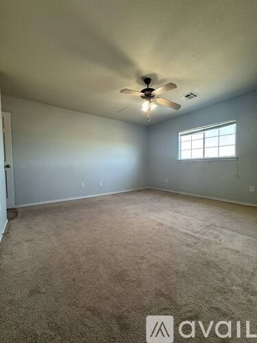 A room with a ceiling fan and a window.