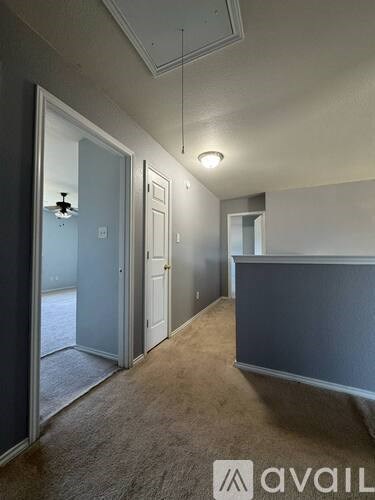 A room with a carpeted floor and a doorway leading to another room.