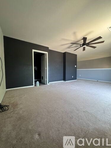A room with a ceiling fan and a carpeted floor.