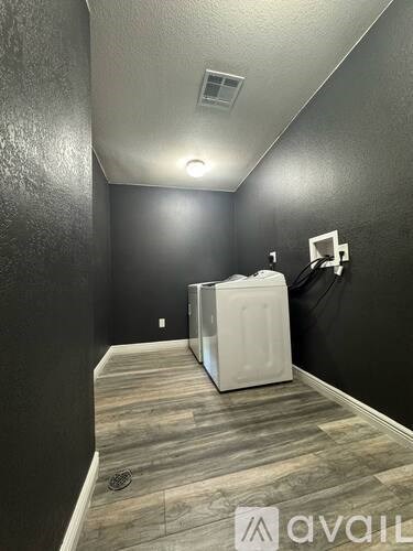 A long, narrow hallway with a white refrigerator in the middle.