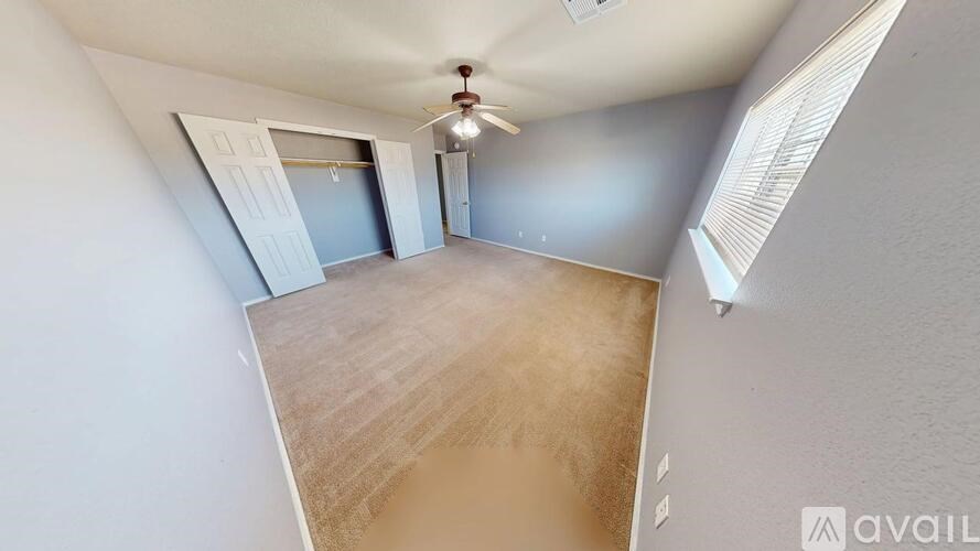 A room with a ceiling fan and wooden flooring.