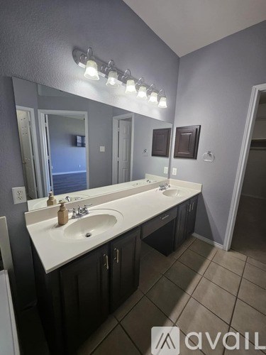 A bathroom with two sinks and a large mirror.