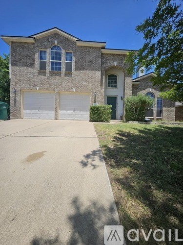 A house with a garage and a driveway in front of it.