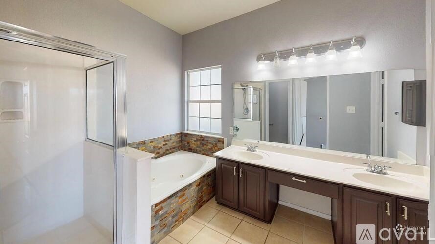 A bathroom with a tub, sink, and mirror.