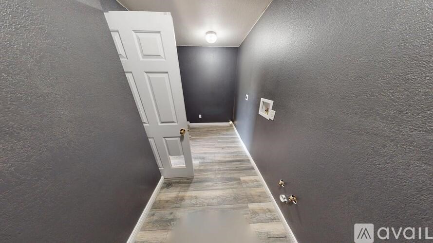 A room with a white door and a grey wall.