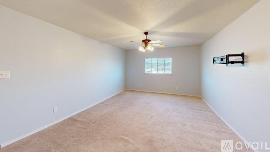 A room with a ceiling fan and a window.