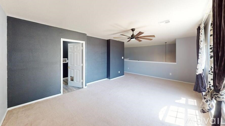 A room with a ceiling fan and a door.