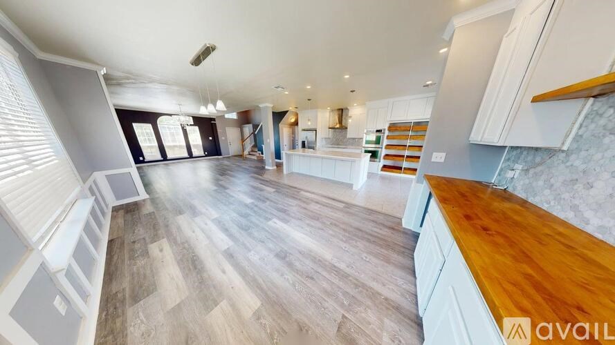 A spacious room with wooden floors and a large window.