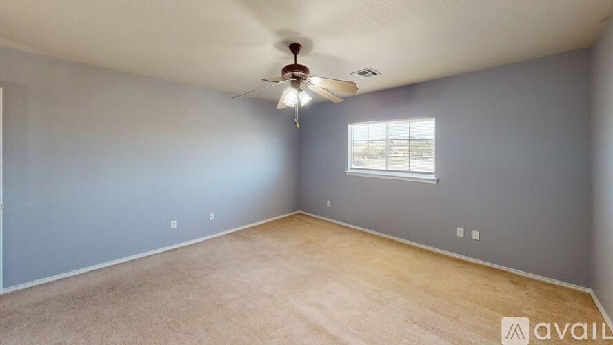 A room with a ceiling fan and a window.