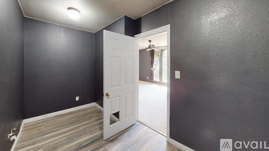 A room with a white door leading to a hallway.