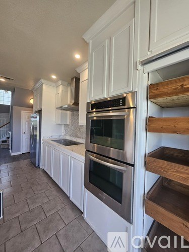 A kitchen with white cabinets and a tile floor.