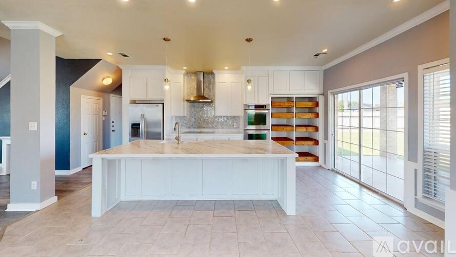 A spacious kitchen with a central island and a view of the backyard.
