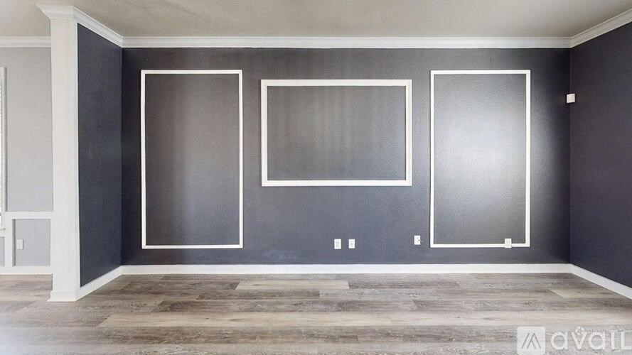 A room with a grey wall and a wooden floor.