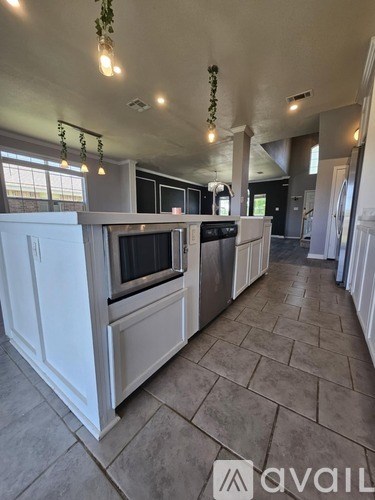 A kitchen with white cabinets and a tiled floor.