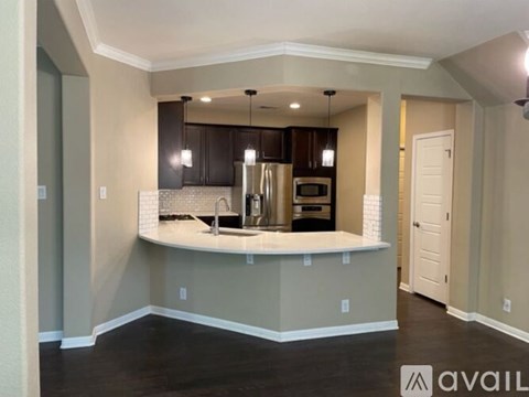 A modern kitchen with dark brown cabinets and a white countertop.