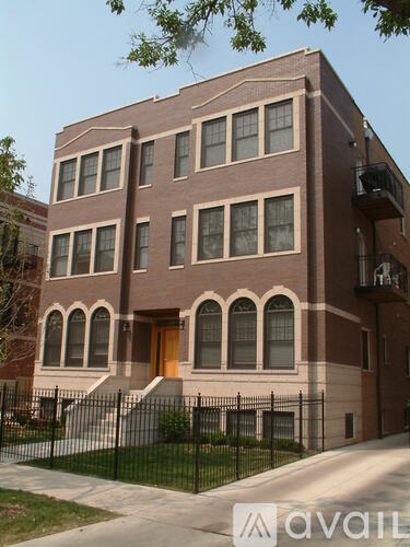 A brown building with a black fence in front.