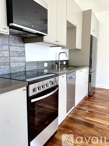 A kitchen with a black oven and white cabinets.